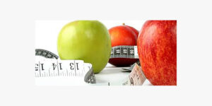 A selection of red and green apples and a measuring tape.