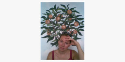 Abigail Grey portrait with painting of fruit tree in background.