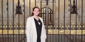 Olivia Taylor stood outside black and gold gates of public building