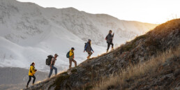 Group of people climbing up a mountain.